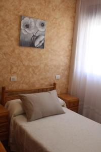 a bedroom with a bed and a picture on the wall at Mesón da Pedra in Burela de Cabo +23 photos