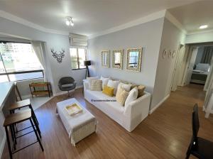 sala de estar con sofá blanco y mesa en Apartamento Decorado Coral, en Balneário Camboriú