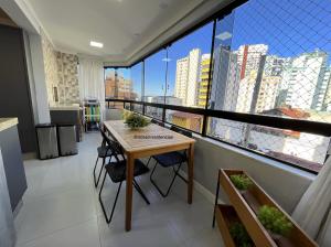 mesa y sillas en una habitación con ventana grande en Apartamento Decorado Coral, en Balneário Camboriú