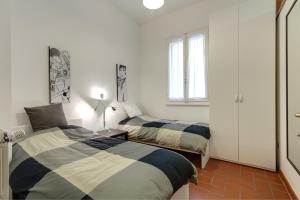 1 dormitorio con 2 camas y ventana en Oche, en Florencia