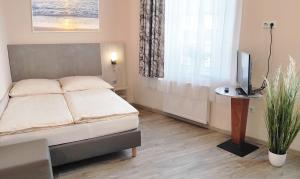 a bedroom with a bed and a tv and a window at Abtei Hotel in Brauweiler