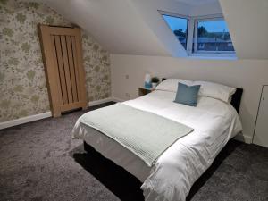 a bedroom with a large white bed with a window at Milne Apartment 2 in Milnrow