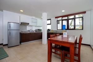 a kitchen with a wooden table and a refrigerator at Galapagos Apartments - Bay View House in Puerto Ayora