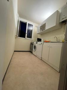 a kitchen with a washer and dryer in a room at Studio aux portes de Paris in Chatou