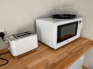 a microwave sitting on a counter next to a toaster at Kitty’s Place, Apartment, Eden Valley, Cumbria in Brampton