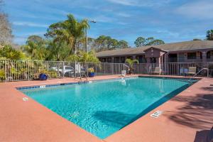 a swimming pool in front of a house at Best Western Apalach Inn in Apalachicola