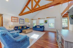 a living room with blue couches and a table at Oyster Pond Paradise in West Tisbury