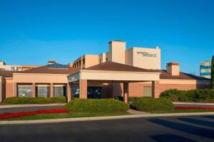 a building with a sign on the side of a street at Sonesta Select Indianapolis Carmel in Carmel