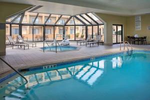 a large swimming pool in a hotel with a patio at Sonesta Select Indianapolis Carmel in Carmel