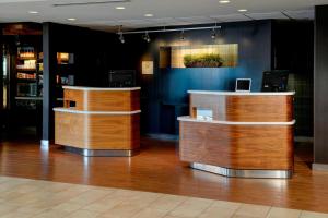 a lobby with two wooden counters in a room at Sonesta Select Kansas City South Overland Park in Kansas City