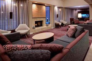 a hotel lobby with couches and a fireplace at Sonesta Select Kansas City South Overland Park in Kansas City