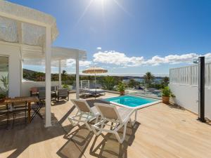 un patio con tavolo, sedie e piscina di Pasitoblanco Porto Mare 7 Seaview Villa private heated pool a Pasito Blanco