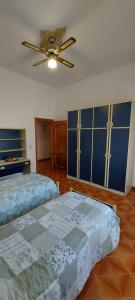 een slaapkamer met 2 bedden en een plafondventilator bij Casa Vacanza alloggio Casa Maria in Sennori