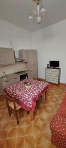 a kitchen with a table in the middle of a room at Casa Vacanza alloggio Casa Maria in Sennori