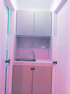 a kitchen with a sink in a pink cabinet at Lee Residences by JAL in Legazpi