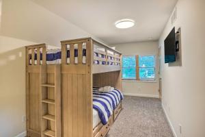 a bedroom with two bunk beds and a television at Renovated Lake Geneva Home Near Dtwn and Beach! in Lake Geneva