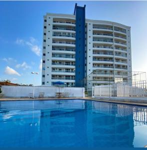 a building with a swimming pool in front of a building at APARTAMENTO LUXUOSO A 1KM DA LITORÂNEA in São Luís