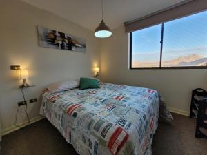 ein Schlafzimmer mit einem Bett und einem großen Fenster in der Unterkunft Atacama Valley 03 in Copiapó