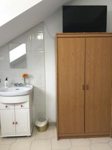 a bathroom with a sink and a cabinet with a tv at Pensión El Pozo in Cudillero