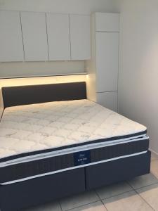 een bed in een kamer met een stevig matras bij Studio 4 pers met Frontaal Zeezicht & privé zwembad Oostende in Oostende +7 foto's