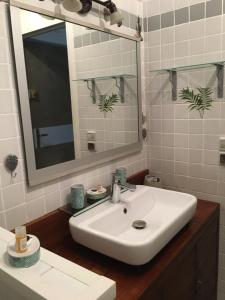 a bathroom with a white sink and a mirror at T1 bis verdoyant in Cayenne