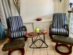 a room with two chairs and a table with an apple on it at T1 bis verdoyant in Cayenne