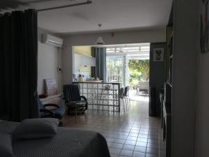 a living room with a bed and a living room with chairs at T1 bis verdoyant in Cayenne
