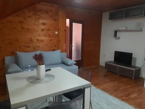 Apartman Ljiljan في نيشْ: غرفة معيشة مع طاولة بيضاء وأريكة