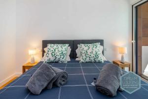 a bed with pillows and a cat laying on it at Albufeira Prime 1B - Dream Lodging in Albufeira +31 photos