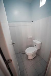 a bathroom with a white toilet in a stall at HK Hotel Kbartolo in Lucena