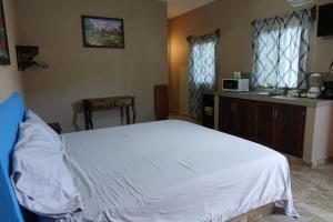 Bungalows Victoria في لا مانزايلا: غرفة نوم بسرير ابيض وميكرويف