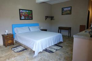Schlafzimmer mit einem Bett mit blauem Kopfteil in der Unterkunft Bungalows Victoria in La Manzanilla