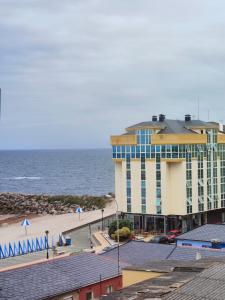 a hotel on the beach with the ocean in the background at Mesón da Pedra in Burela de Cabo