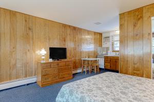 a bedroom with a bed and a tv and a table at King Birch Lake Homes in Alton