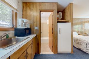 a kitchen with a sink and a refrigerator next to a bed at King Birch Lake Homes in Alton