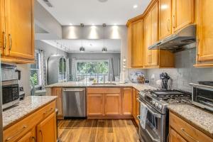a kitchen with wooden cabinets and stainless steel appliances at Oyster Bay Villas --- 37500 Kaitlyn Dr Unit #23 in Rehoboth Beach