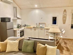 a living room with a couch and a kitchen at Le Cosy Porgeais in Le Porge