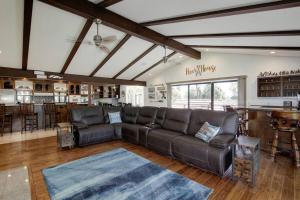 a living room with a leather couch and a bar at Relaxing River-View Retreat Near Sacramento in Nicolaus