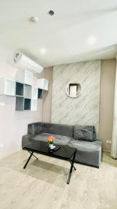 a living room with a couch and a table at The base condo 142 by Pupu in Pattaya Central