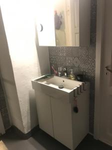 a bathroom with a white sink and a mirror at Dr Haave- middle of nowhere, pikeværelset in Sand