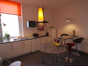 uma cozinha com uma mesa e algumas cadeiras e um lavatório em Gîte Épinal, 3 pièces, 5 personnes - FR-1-589-92 em Épinal