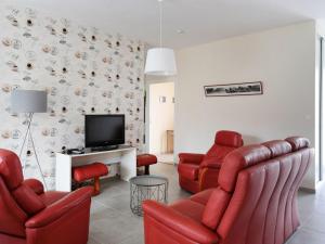 uma sala de estar com cadeiras vermelhas e uma televisão em Gîte Mardié, 3 pièces, 4 personnes - FR-1-590-132 em Mardié