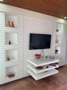 eine Wand mit einem Flachbild-TV in einem Zimmer in der Unterkunft Flat 607 VILLA HÍPICA in Gravatá