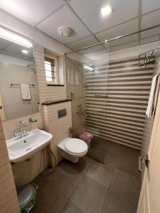 a bathroom with a toilet and a sink and a mirror at RAMAS GARDEN in Trivandrum