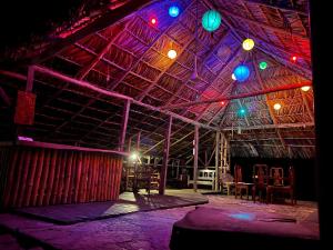 um quarto com um tecto de madeira com luzes coloridas em Cabañas Bambután em Palenque