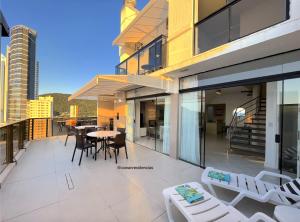 a balcony with a table and chairs on a building at Cobertura Quebec Beira-Mar in Balneário Camboriú