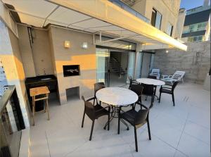 a patio with tables and chairs and a fireplace at Cobertura Quebec Beira-Mar in Balneário Camboriú