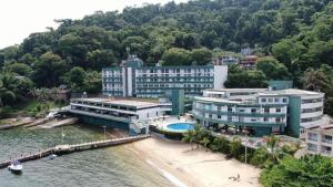 a hotel on the beach next to the water at Angra Inn - Praia Grande 318 in Angra dos Reis