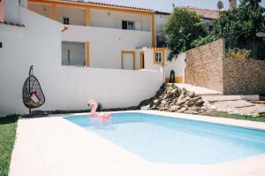 a swimming pool with a pink flamingo in a house at Quintinha do Quintas in Valhascos