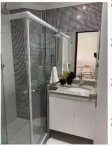 y baño con ducha, lavabo y espejo. en Flat 607 VILLA HÍPICA, en Gravatá